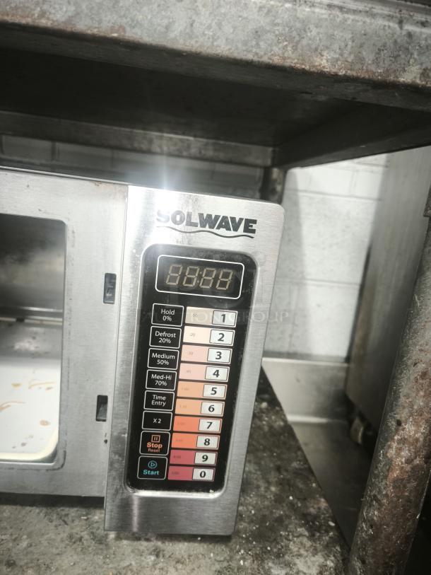 SOLWAVE commercial stainless steel microwave with digital controls, various power settings, visible wear. Ideal for restaurants.