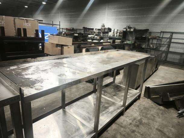 Stainless steel table with 1 shelf, showing wear and surface marks. Ideal for commercial or industrial use.