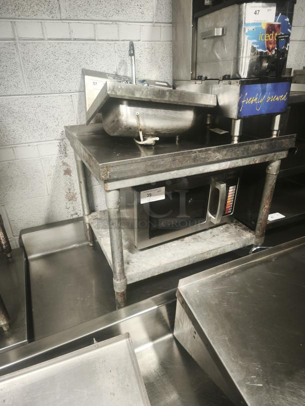 Stainless Steel Table with 1 shelf, visible wear and rust, includes industrial equipment, labels indicate inventory numbers.