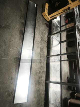 Stainless steel kitchen shelf, elongated design, excellent condition, suitable for industrial use, reflective surface.