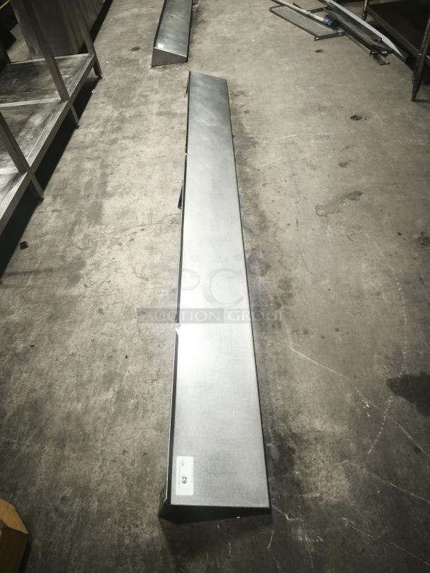 Stainless steel kitchen shelf in excellent condition, featuring a sleek, durable design. Auction tag labeled "20" visible.