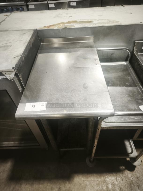 Heavy-duty small stainless prep table with backsplash, showing some wear, auction tag labeled "72 QTY", sturdy build.