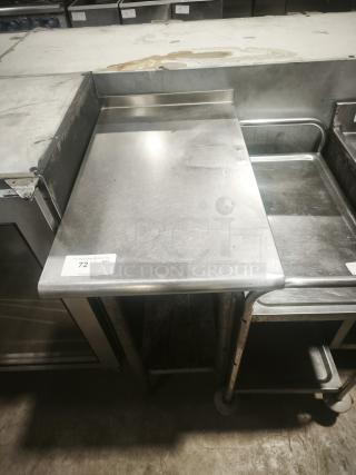 Heavy-duty small stainless prep table with backsplash, showing some wear, auction tag labeled "72 QTY", sturdy build.