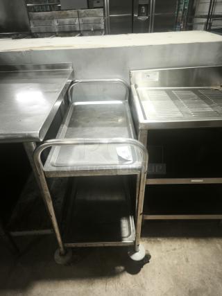 Heavy-duty small stainless steel prep table with two shelves, wheels, and a label marked "73." Sturdy condition.