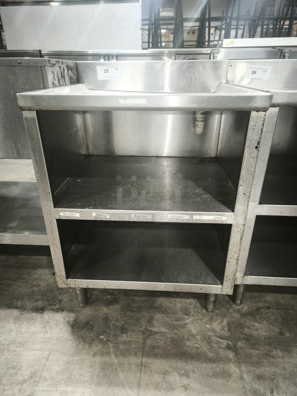 Heavy-duty stainless steel pan rack with two shelves, labels for organizing, some wear visible, ideal for commercial kitchens.