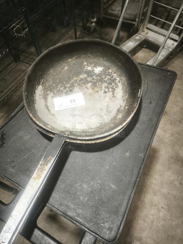 Stainless clad frying pan, 16-inch, with visible wear and rust on handle. Auction tag marked "82" attached inside.