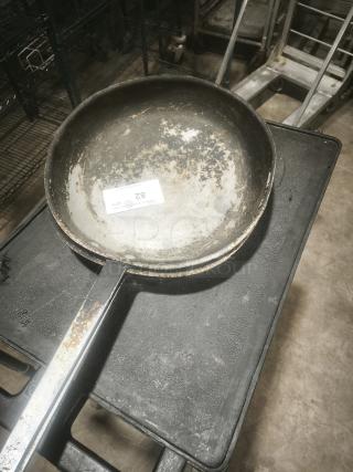 Stainless clad frying pan, 16-inch, with visible wear and rust on handle. Auction tag marked "82" attached inside.