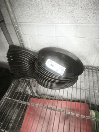 Lodge 10 x 7.5 inch cast iron oval serving griddle with teardrop handle; stack of several pans, black.