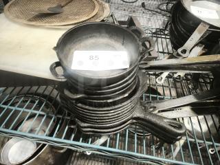 Pre-seasoned mini cast iron round casserole dish, stacked with others. Tag reads "85 QTY." Good condition, robust handles.