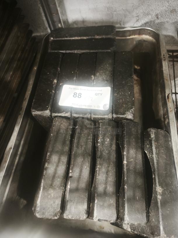 Heavy-duty black metal bars in used condition, stacked in a metal tray. Label shows quantity "88" and refers to PCIauctions.com.