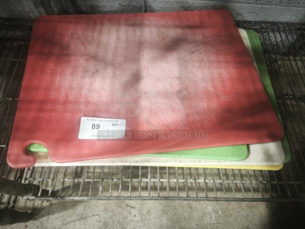 Red heavy-duty plastic chopping board, anti-slip, dishwasher safe, stack of color-coded boards, visible wear.