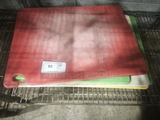 Red heavy-duty plastic chopping board, anti-slip, dishwasher safe, stack of color-coded boards, visible wear.