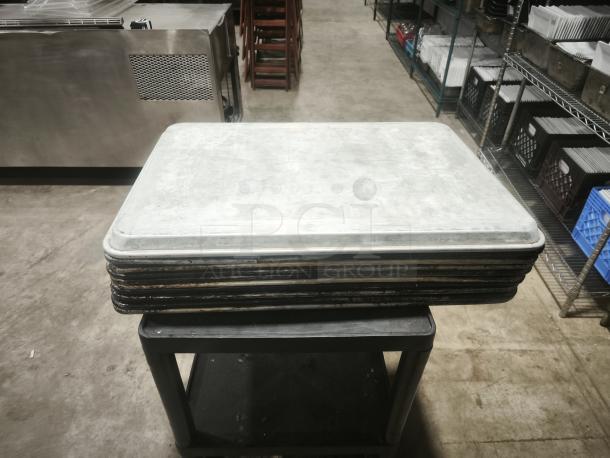 Stainless steel deep bakeware pan with BPA-free plastic lid, USA made. Stack of pans, industrial setting, minimal wear.