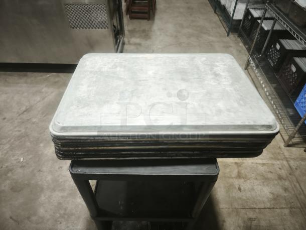 Stainless steel deep bakeware pan with BPA-free clear plastic lid, made in USA, shown on a display stand.