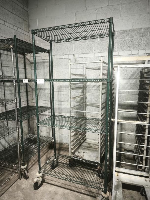 Green epoxy wire shelf on wheels, four-tier, used condition, suitable for storage or industrial use.
