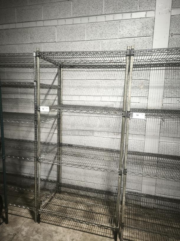 Epoxy wire shelf with four tiers, metal finish, good condition, ideal for storage. Visible labels showing numbers 96 and 94.