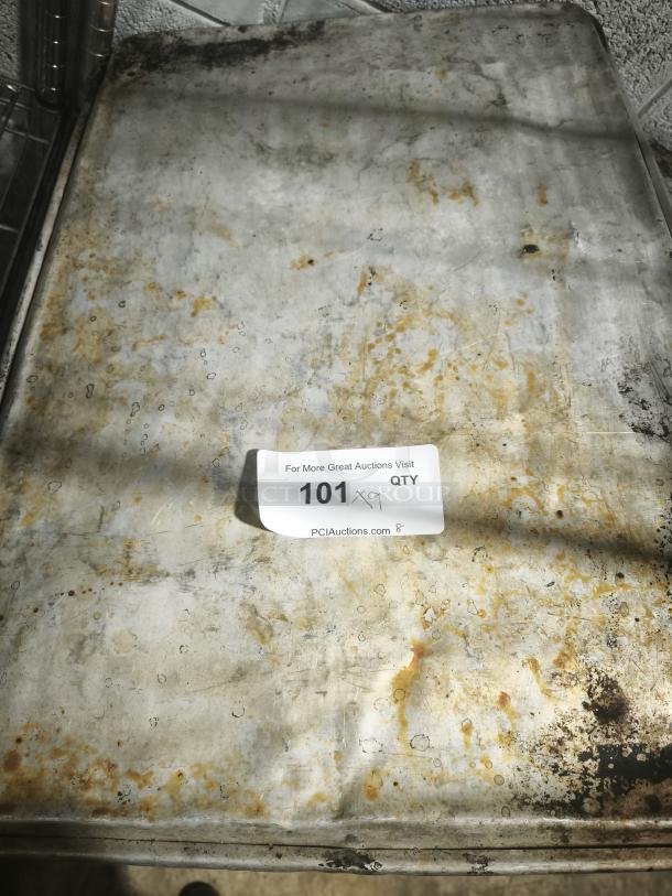 Aluminum cake baking pan with worn surface, visible age spots; auction tag reads "101 x9 QTY" from PCIAuctions.com.