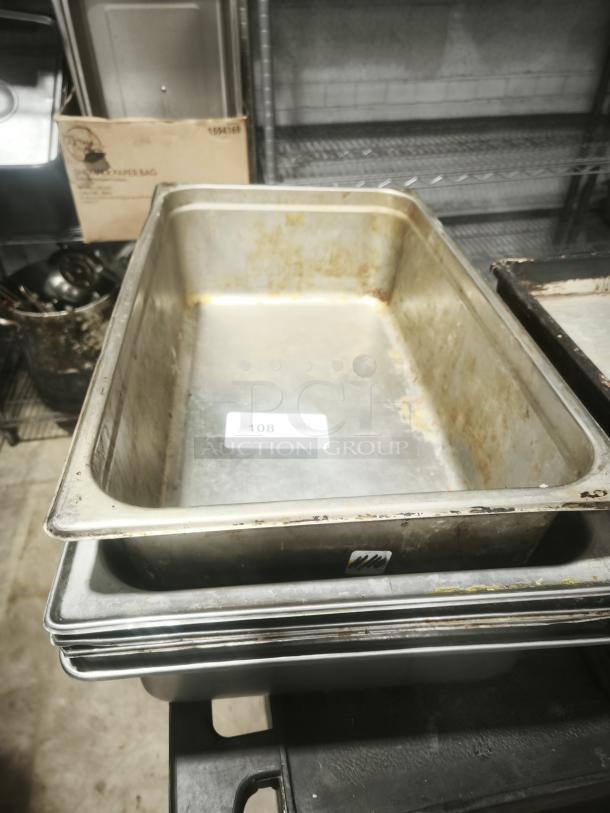Stainless steel steam table pans, full size, 4" deep, stacked. Visible wear and number tag 108 indicating item ID.