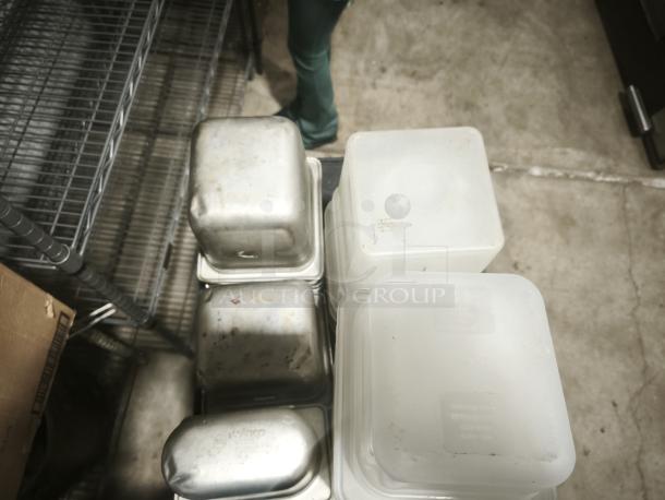 Stacked food containers of varying sizes, including stainless steel and translucent plastic types, some with visible marks.