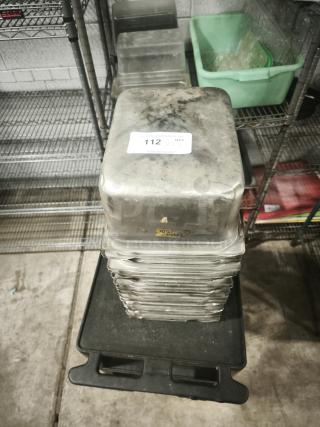 Stainless steel steam table pans, half full size, 6" deep, stacked, with visible wear. Auction label "112 x 19".