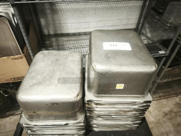 Stainless steel steam table pans, half full size, 6" deep, stacked. Visible stickers indicate auction lot number and condition.