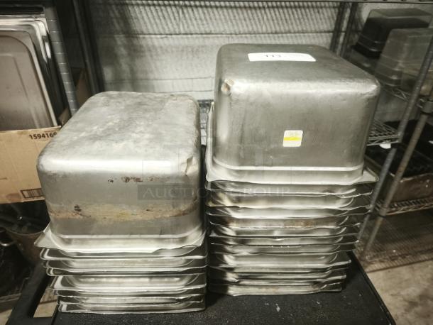 Stainless steel steam table pans, half full size, 6" deep, stacked, showing signs of wear and rust.