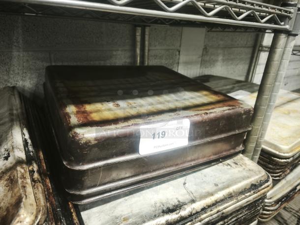 Rusted stainless steel cooking pan, 16 inches, stacked on a metal shelf. Auction label marked "119 x 4."