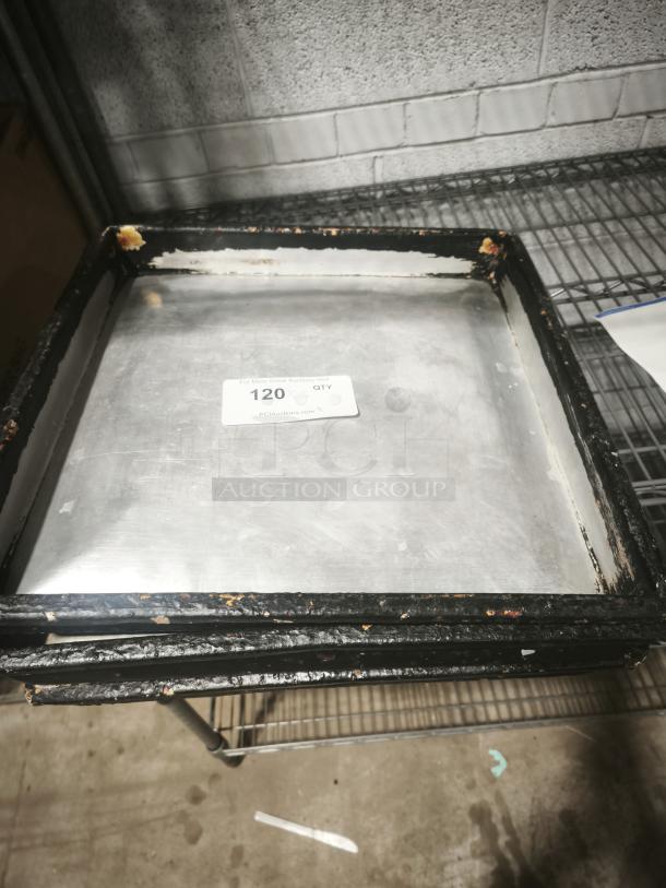 Stainless steel baking tray with blackened edges showing wear, labeled with "120 QTY" tag.