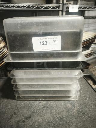 Stack of 1/3 full size pans in used condition, plastic material. Label indicates item number 123.