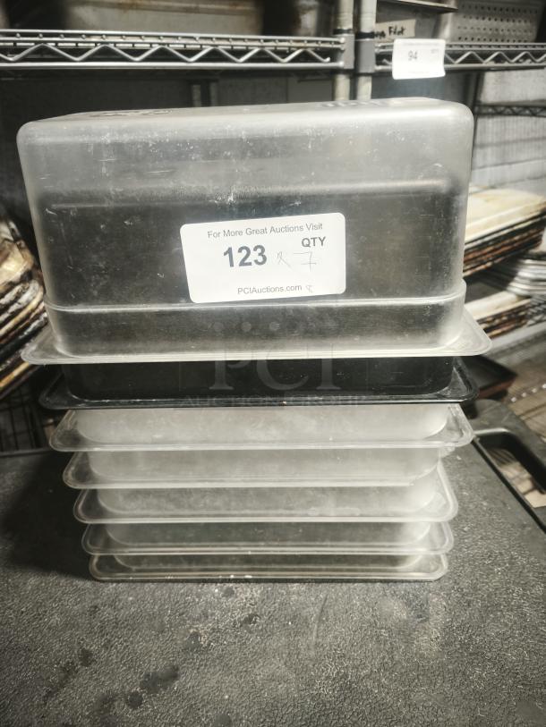 1/3 Full Size Pan stack with clear lids, labeled "123 QTY 7," showing signs of use, suitable for commercial kitchens.