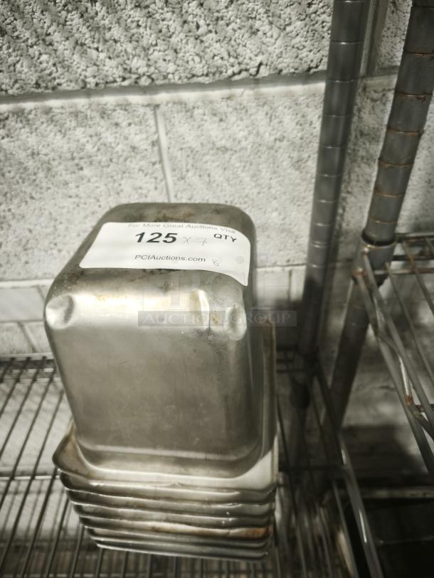 Stack of 1/4 full-size metal pans, showing mild wear. Label reads: "125" with auction info from PCI Auctions.