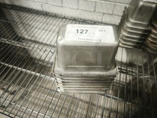 Stack of 1/9 size, 4" deep stainless steel food pans in good condition on a wire shelf.