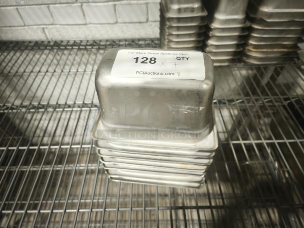 1/9 size, 4" deep food pan stack on wire rack. Silver metal, good condition, labeled "128" for auction identification.