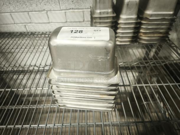 1/9 size, 4” deep stainless steel food pan, stack of 10, with label indicating auction details. Good condition.