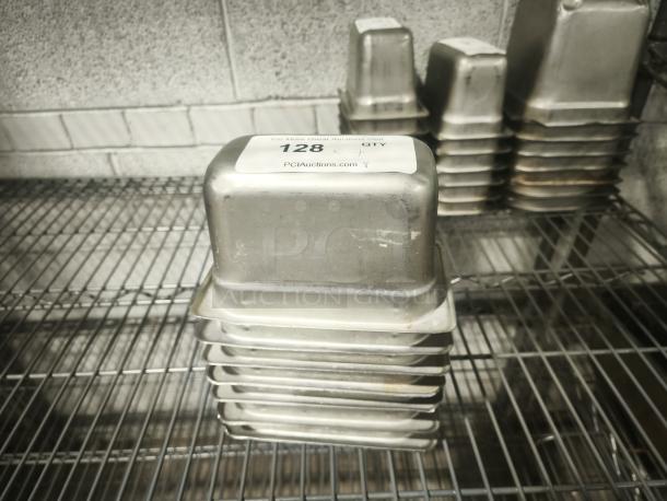 1/9 Size 4" deep stainless steel food pan, stackable, used condition. Marked with auction label "128".