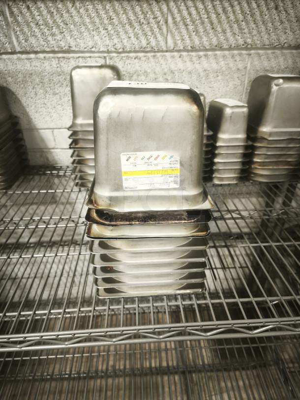 1/6 size, 4" deep stainless steel food pan with visible wear. Label shows usage guidelines; good for commercial kitchen use.