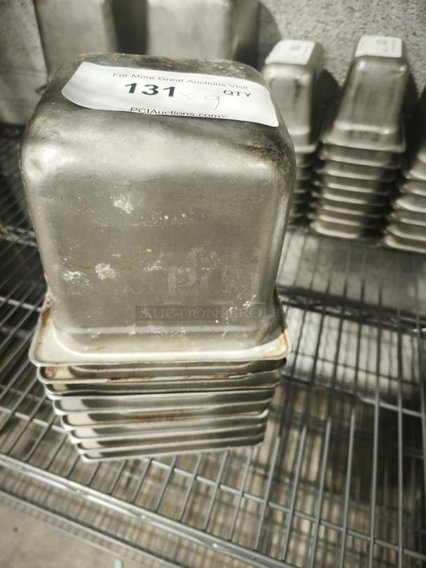 1/6 size 4" deep stainless steel food pan, showing signs of wear. Visible label with auction number and quantity.