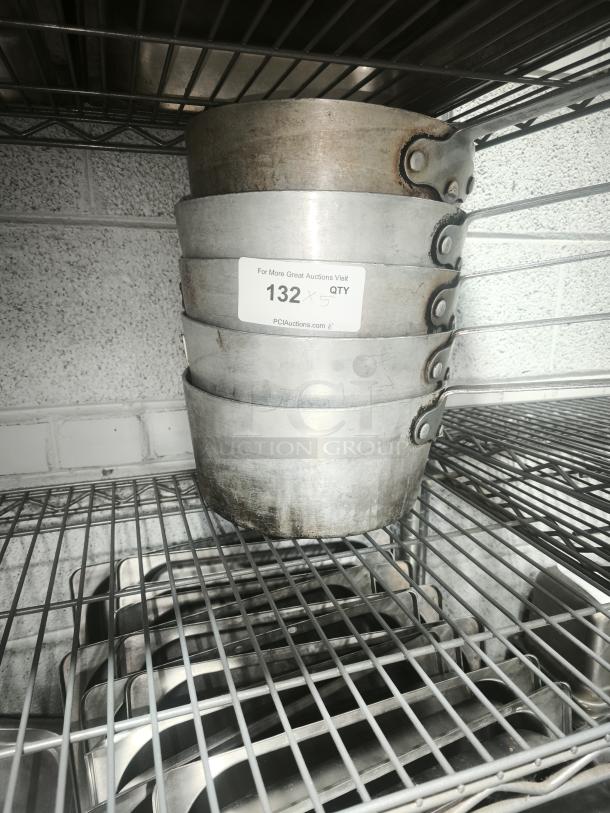 Stack of five heavy gauge sauce pans with visible wear, riveted handles, and a label indicating "132 x 5 QTY".