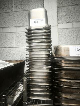 Stack of 1/3 size, 4" deep stainless steel food pans. Auction tag indicates item number 133. Slight wear visible.