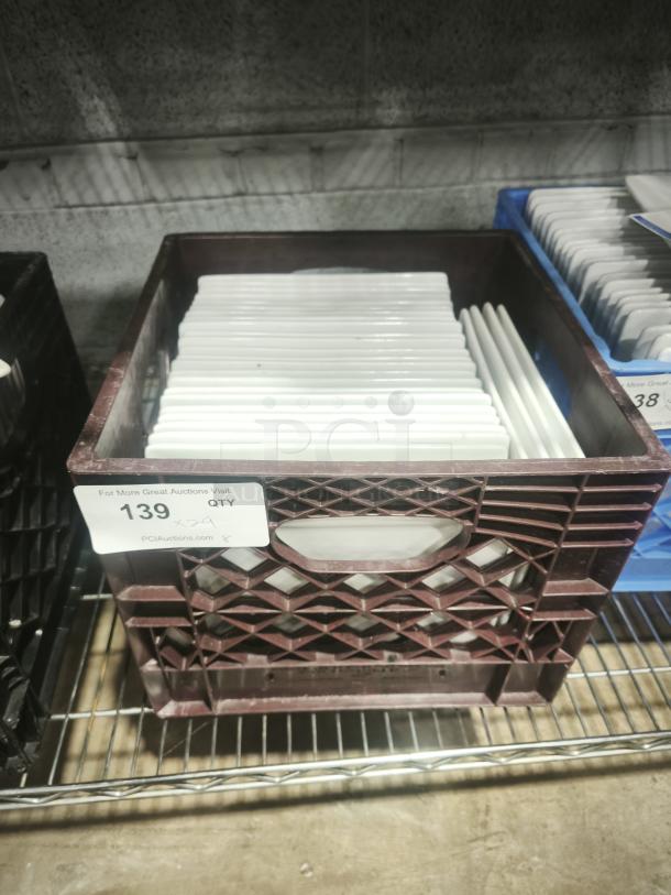 9" bright white square porcelain plates, neatly stacked in a crate. Appears in good condition, suitable for dining use.
