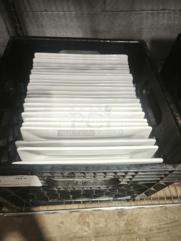 9" bright white square porcelain plates stacked in a black crate, excellent condition, no visible markings or damage.