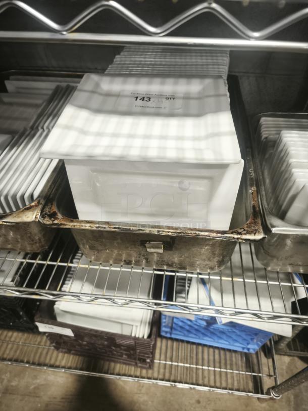 9" bright white square porcelain plates on a metal rack, with a visible label indicating quantity and auction details.