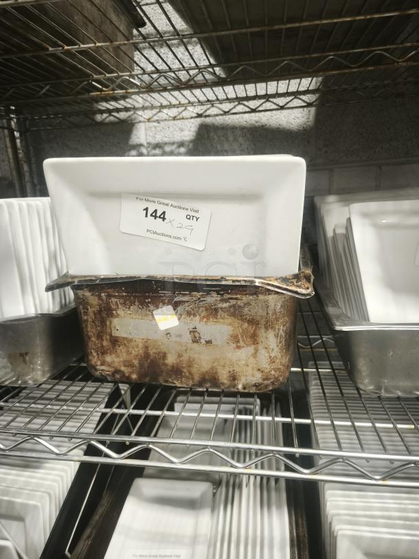 10" bright white square porcelain plate on a metal shelf, with label "144" indicating auction details.