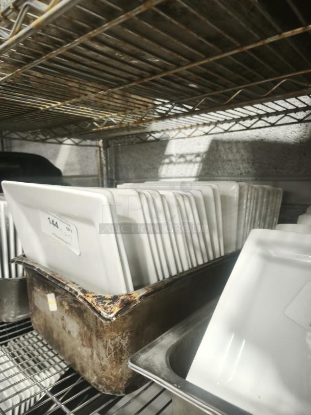 10" bright white square porcelain plates, stacked on a metal shelf. Visible tag "144 qty" indicates quantity. Excellent condition.