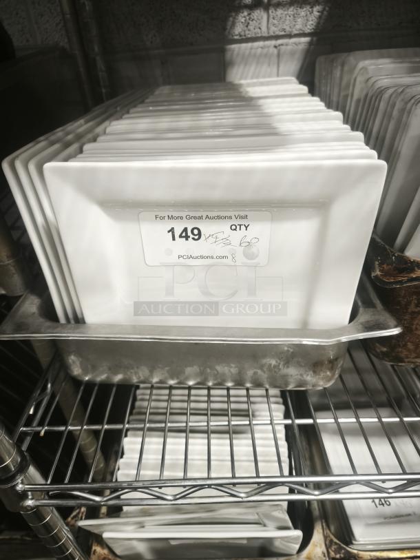 Stack of 9 bright white square porcelain plates on a metal rack; label indicates inventory and auction site details.