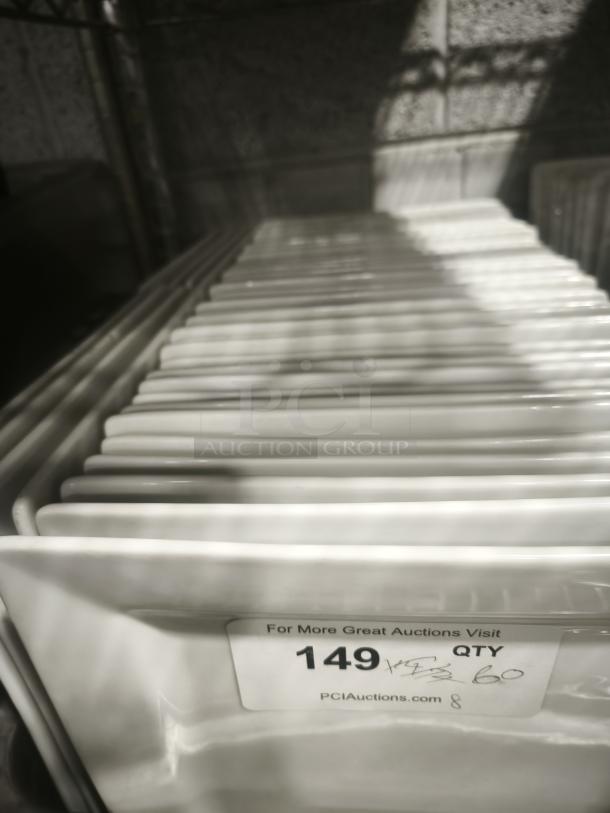 9 bright white square porcelain plates stacked, showing glossy finish. Auction tag labeled "149 QTY" and website.