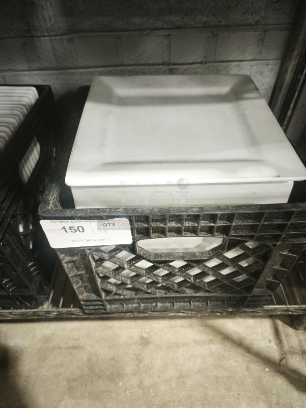 10 bright white square porcelain plates stacked in a crate; pristine condition, suitable for dining or display.