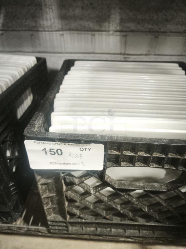10 bright white square porcelain plates stacked in a crate. Label indicates quantity 150. Plates appear new.