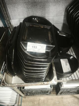 Stack of black iron griddle pans, rectangular, showing wear. Auction tag reads "153 QTY XII," indicating quantity.