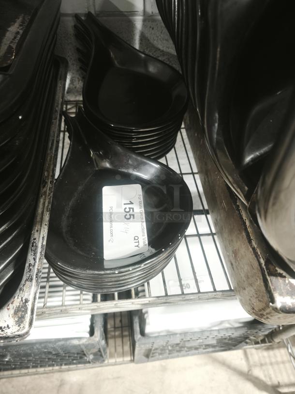 Black ceramic serving dish, elegant teardrop shape, stack of multiple dishes, in excellent condition. Label reads "Lot 155."